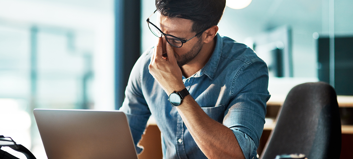 Stress, Mann reibt sich gestresst die Augen.